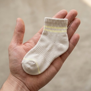 A child's STROMA sock resting in a parent's palm